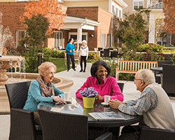 Seniors talking outside with beautiful garden in background